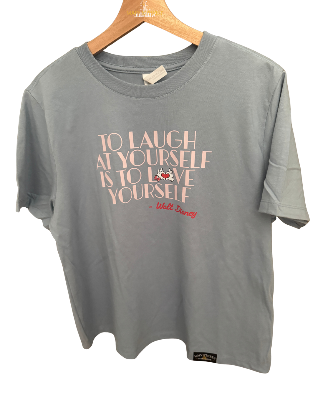 Light blue Disney-inspired t-shirt with 'To laugh at yourself is to love yourself' quote.